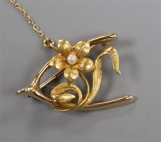 An early 20th century 15ct and seed pearl set flower and wishbone brooch, 31mm.
